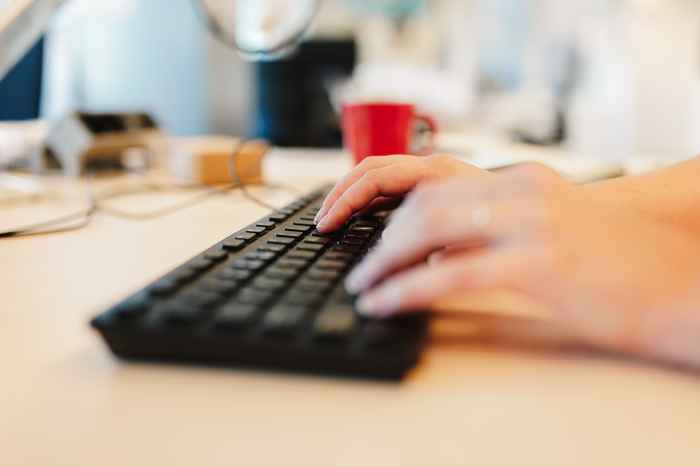 Close up of a hand typing on a keyboard
